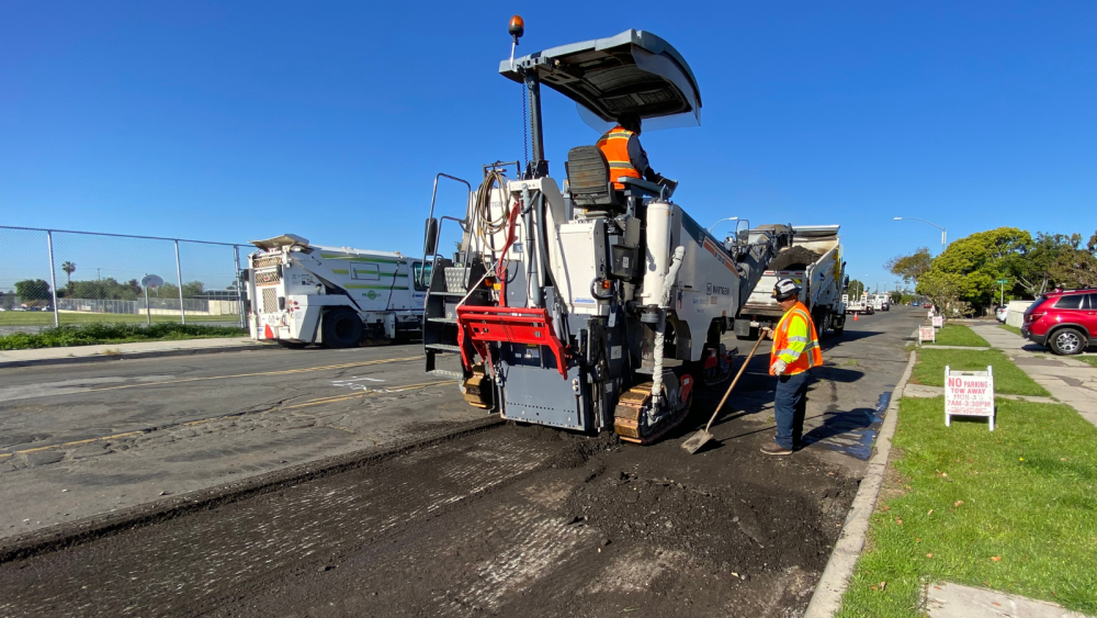 crews working on mill and pave in front of a neighborhood