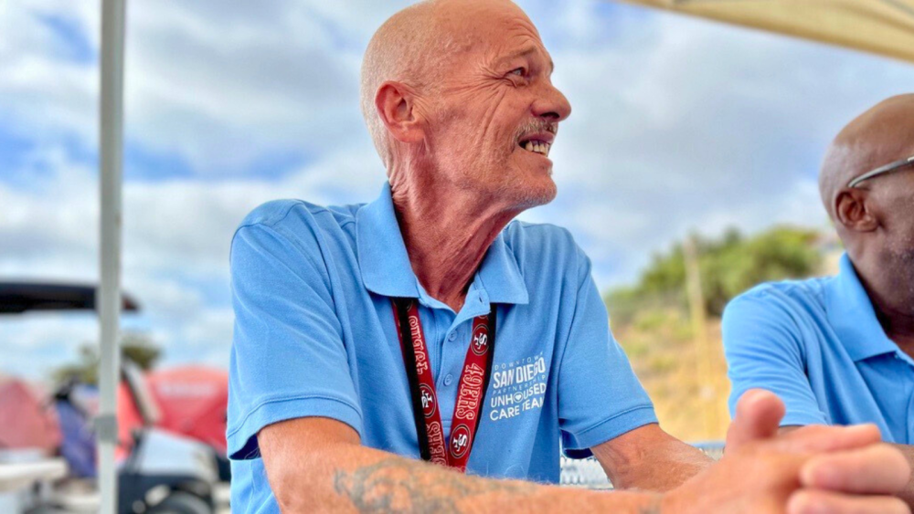picture of man in blue shirt and red lanyard