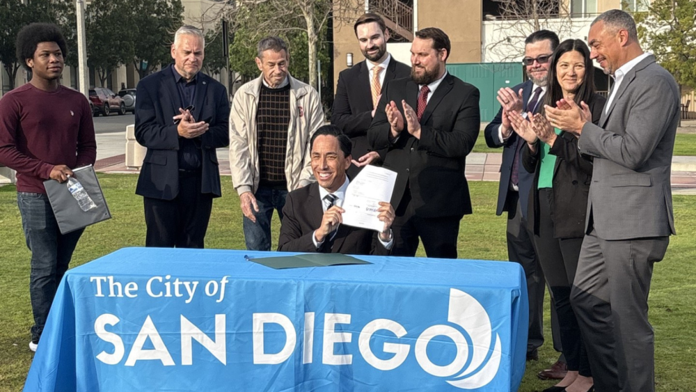 Photo of Mayor sitting a table with ordinance in hand