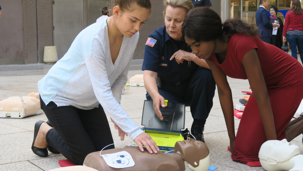Photo of three women simulating CPR