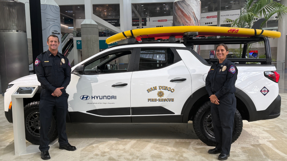 Two lifeguards posing in front of vehicle