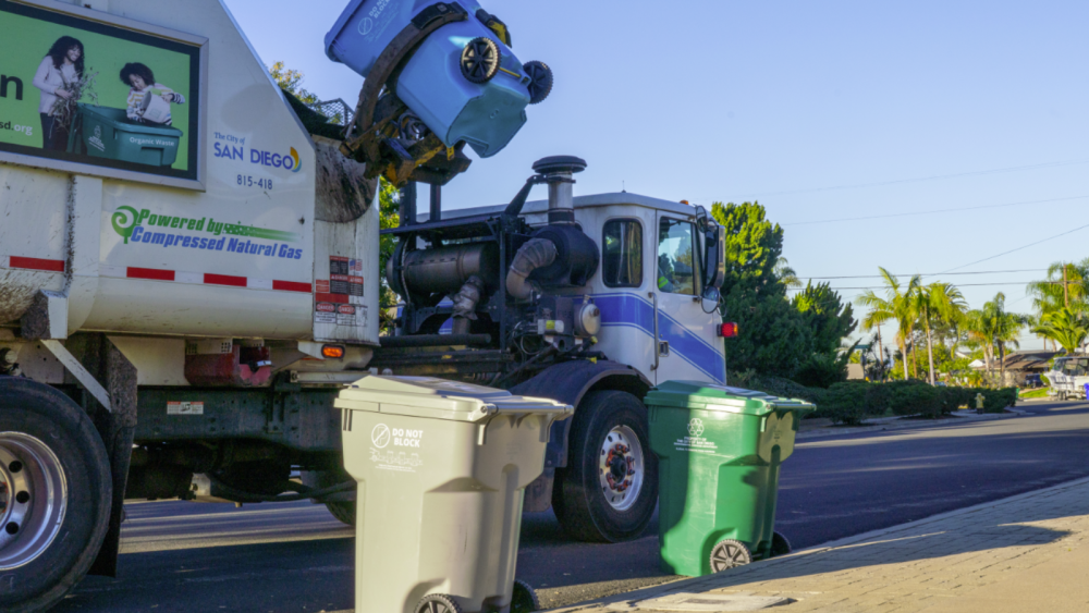 Three trash cans and a truck