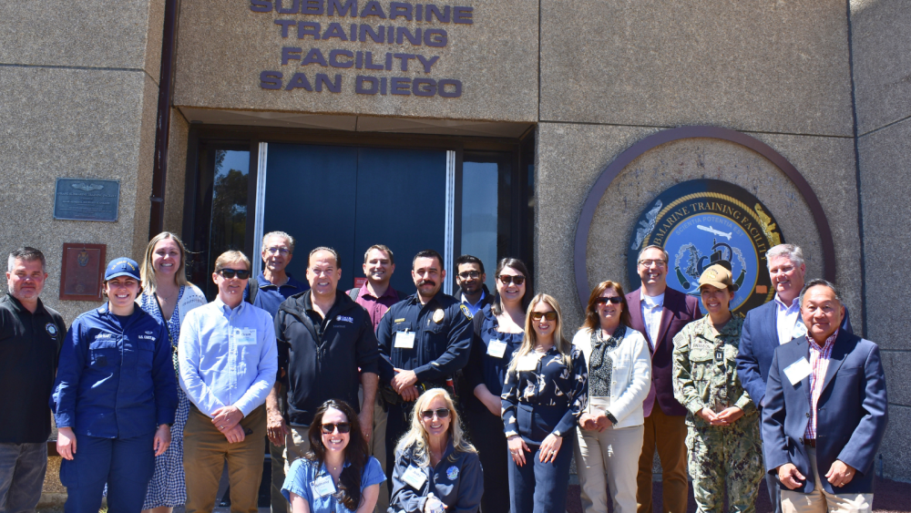 Group of staff standing in front of submarine training facility 