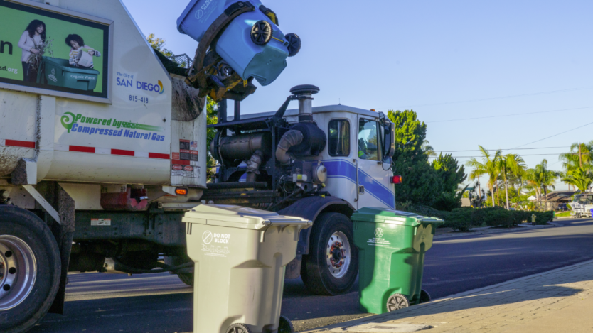 Three trash cans and a truck