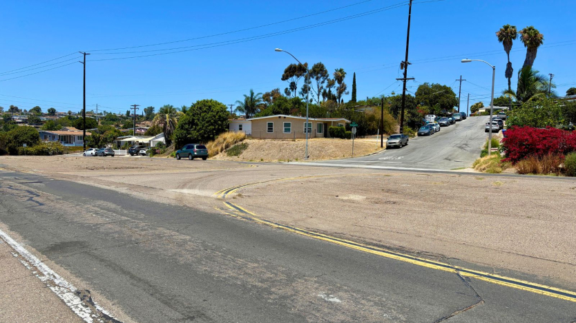 photo of a street with cars parked along the side of the road