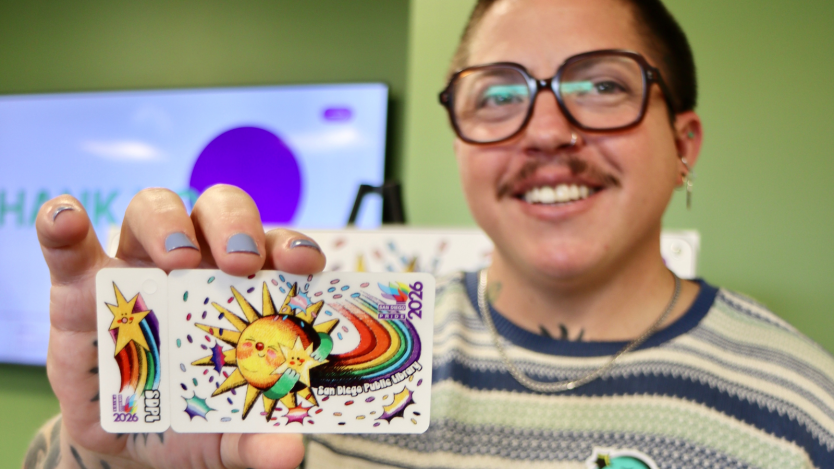 Person showing library card and smiling