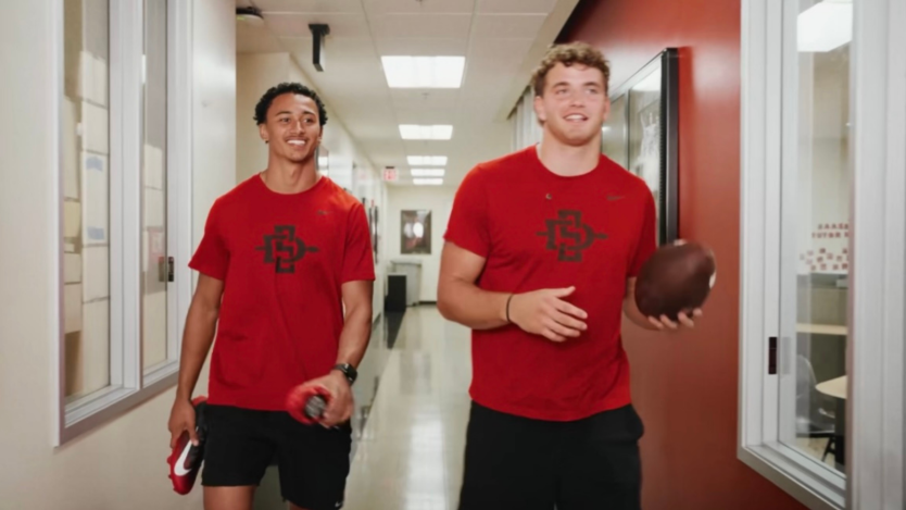 Two Aztec Link students walking and smiling