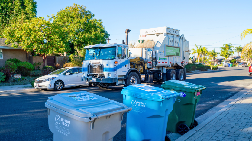 Three trash bins and truck