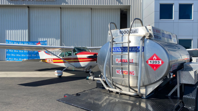 image of airport hanger with small plane and fuel tank